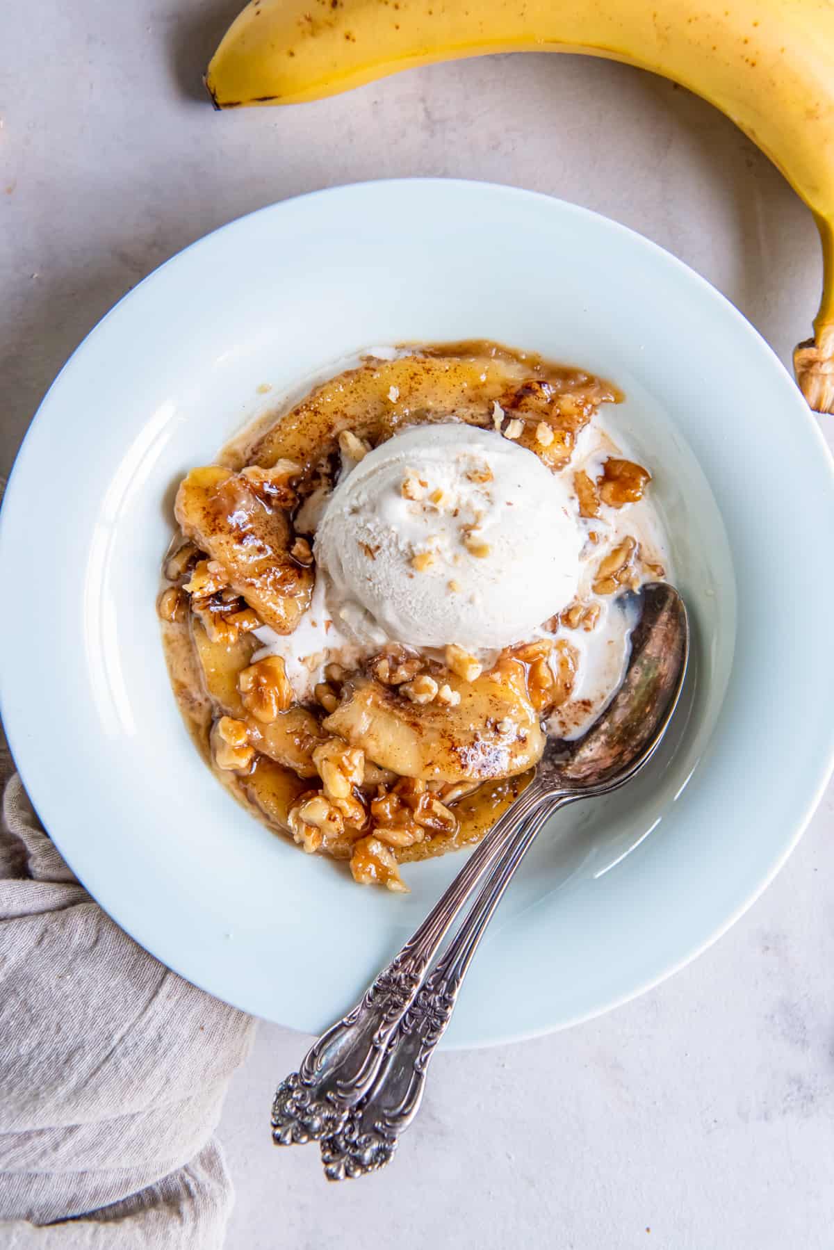 bananas foster in a bowl with two spoons