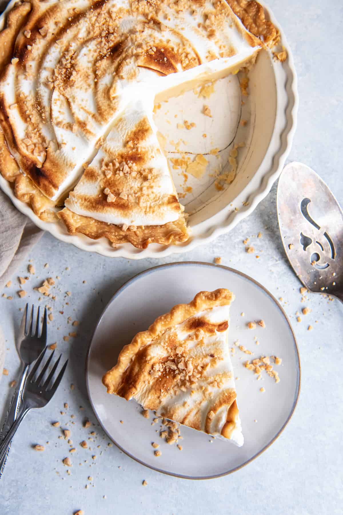 a slice of butterscotch pie on a plate, next to the whole pie