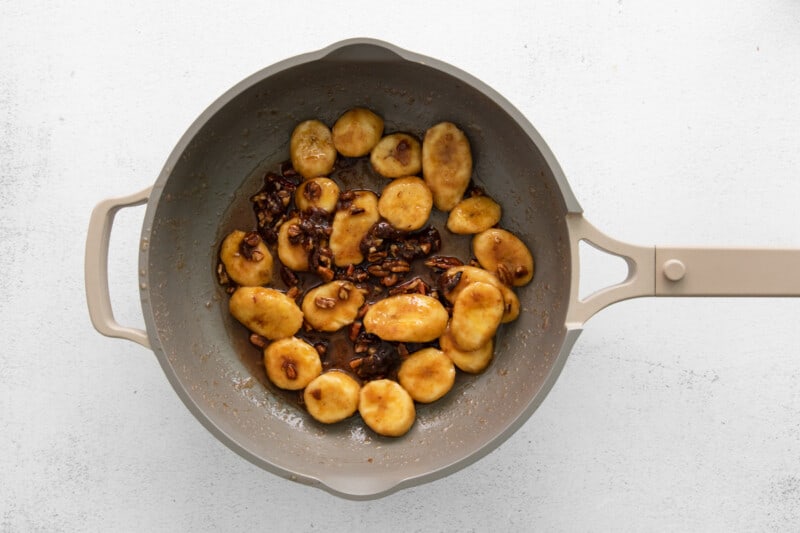 cooking banana slices and walnuts in pot to make the topping