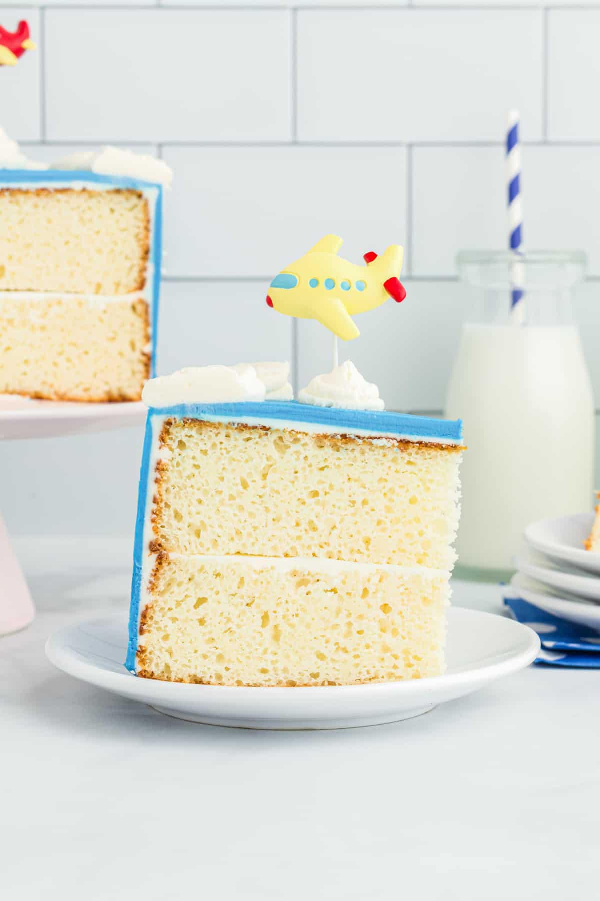 side view of a slice of airplane cake on a white plate.