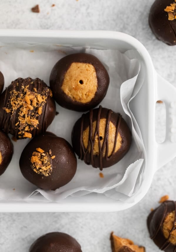 close up of butterfinger balls in a white serving dish.