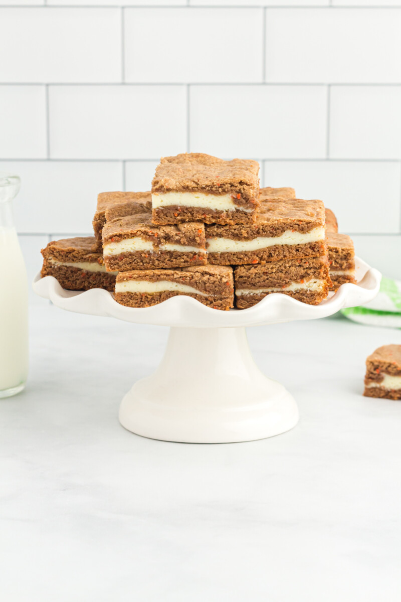 carrot cake bars on a white cake stand.