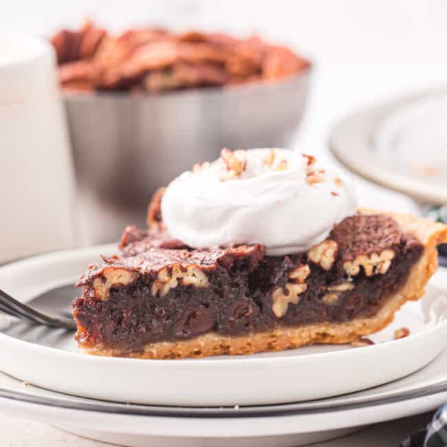 a slice of chocolate pecan pie on a white plate.