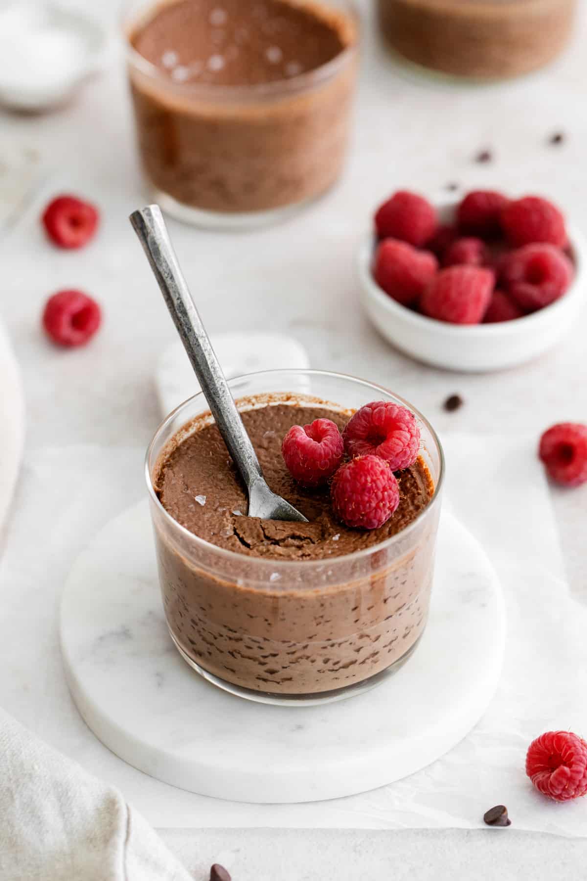 chocolate pot de creme with a spoon and topped with raspberries