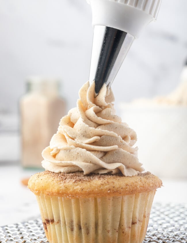 piping brown sugar buttercream onto a cupcake