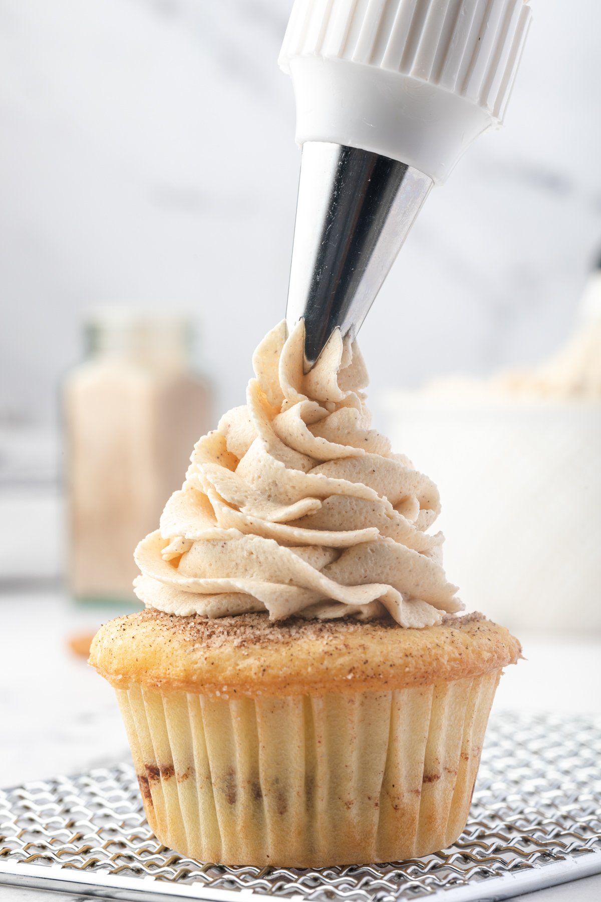 piping brown sugar buttercream onto a cupcake