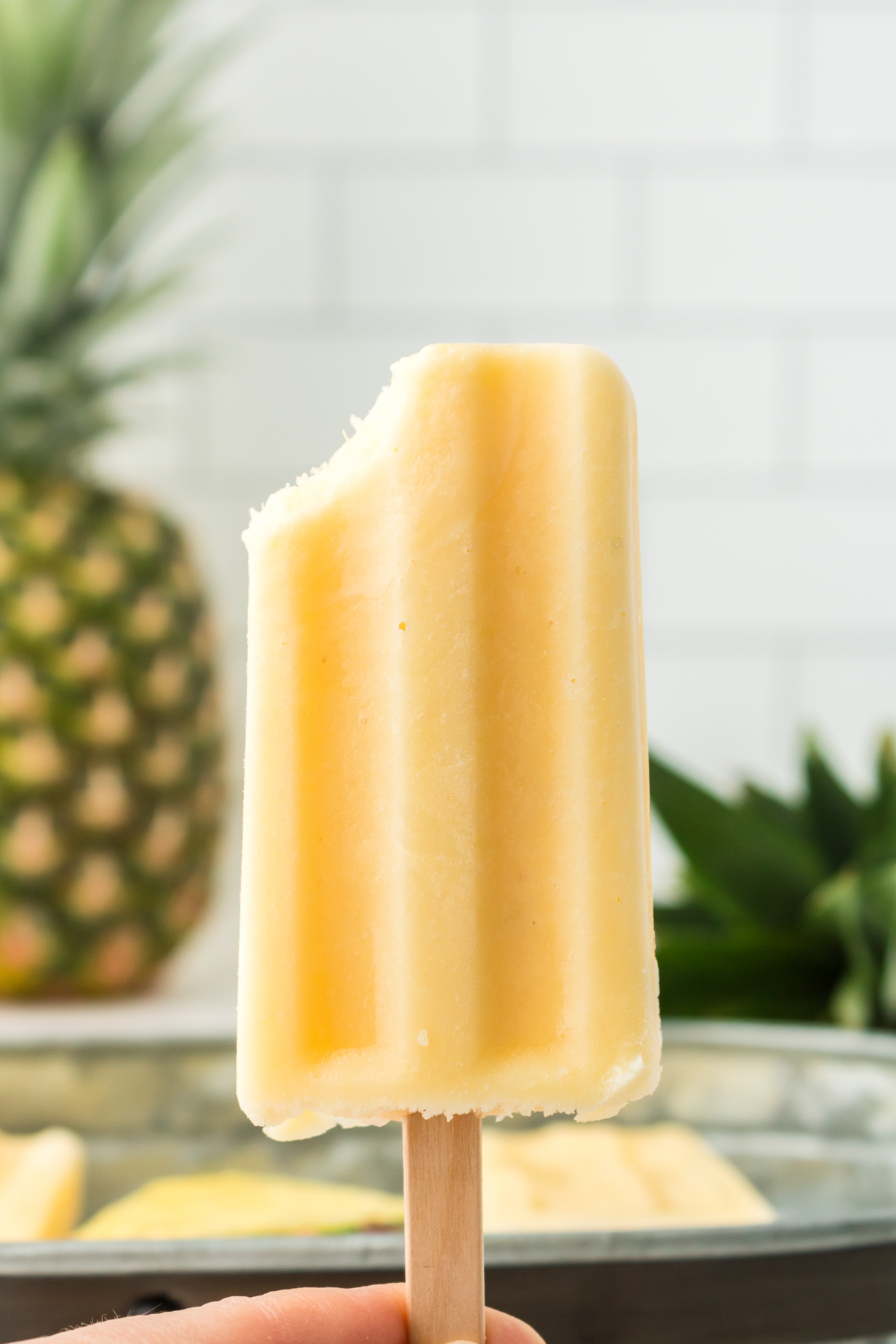 dole whip popsicle with a bite taken out of it