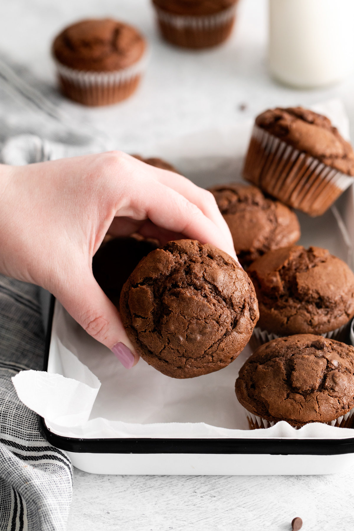 hand grabbing a chocolate muffin
