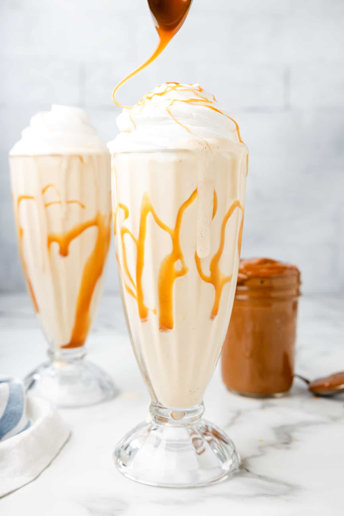 drizzling dulce de leche on top of a milkshake