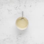 white chocolate ganache in a white bowl with a spoon.