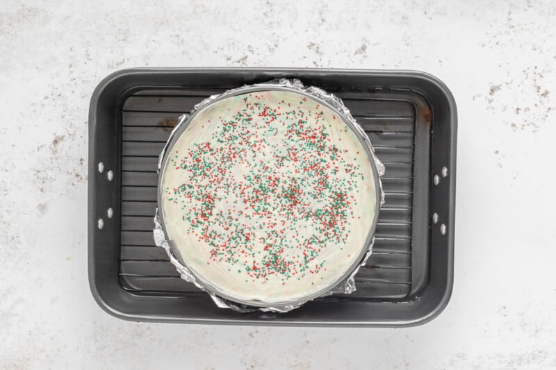 christmas cheesecake in a springform pan set in a water bath.