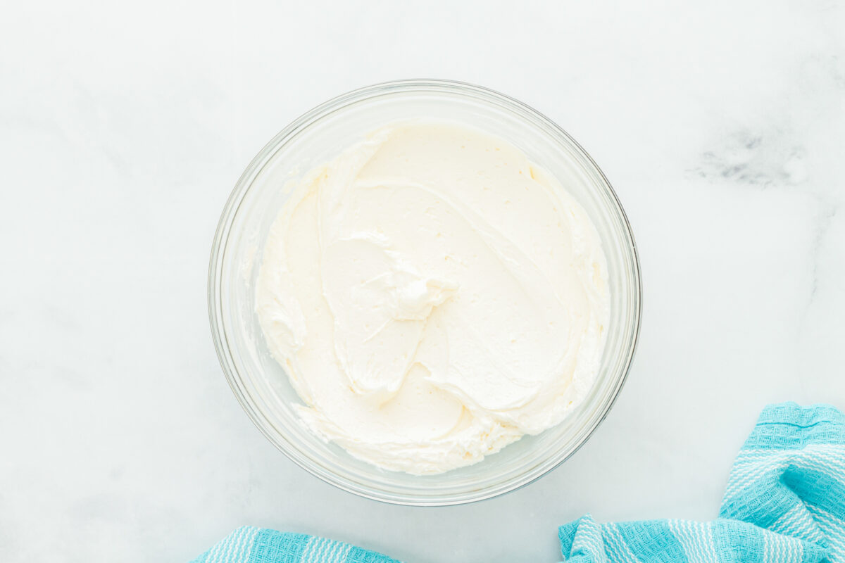 overhead view of frosting for airplane cake in a white bowl.