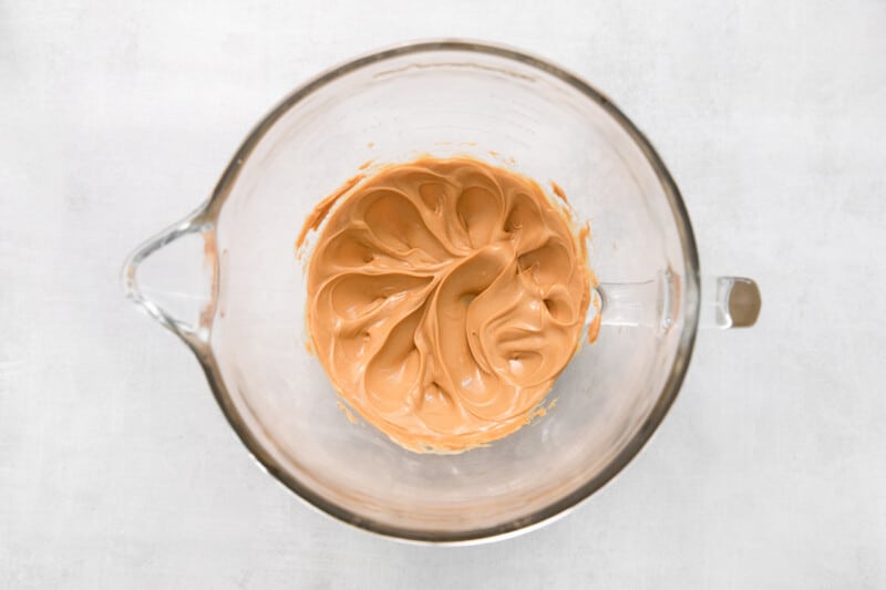 peanut butter and butter mixed in a glass mixing bowl.