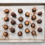 21 chocolate dipped butterfinger balls on a baking sheet.