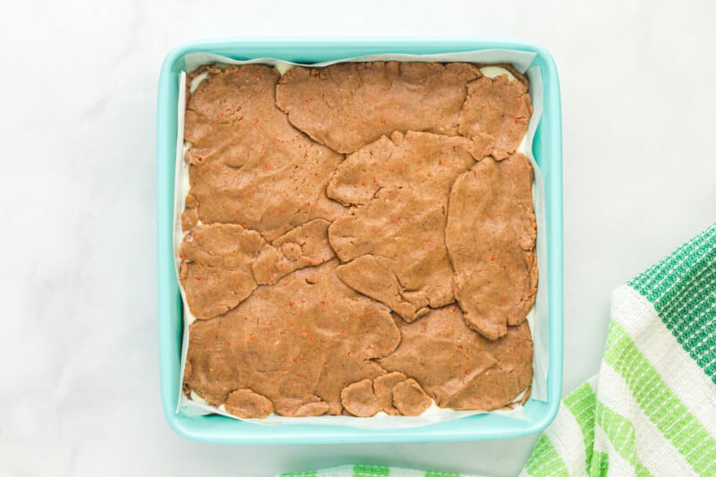 unbaked carrot cake bars in a blue baking pan.