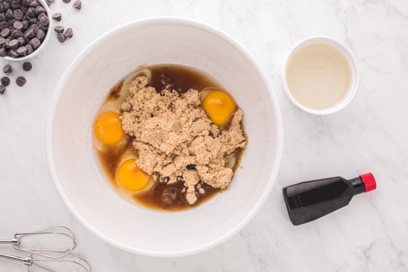eggs and brown sugar in a white bowl.