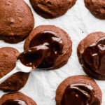 a spoon drizzling ganache over cosmic brownie cookies.