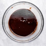 chocolate sauce in a glass bowl on a white background.