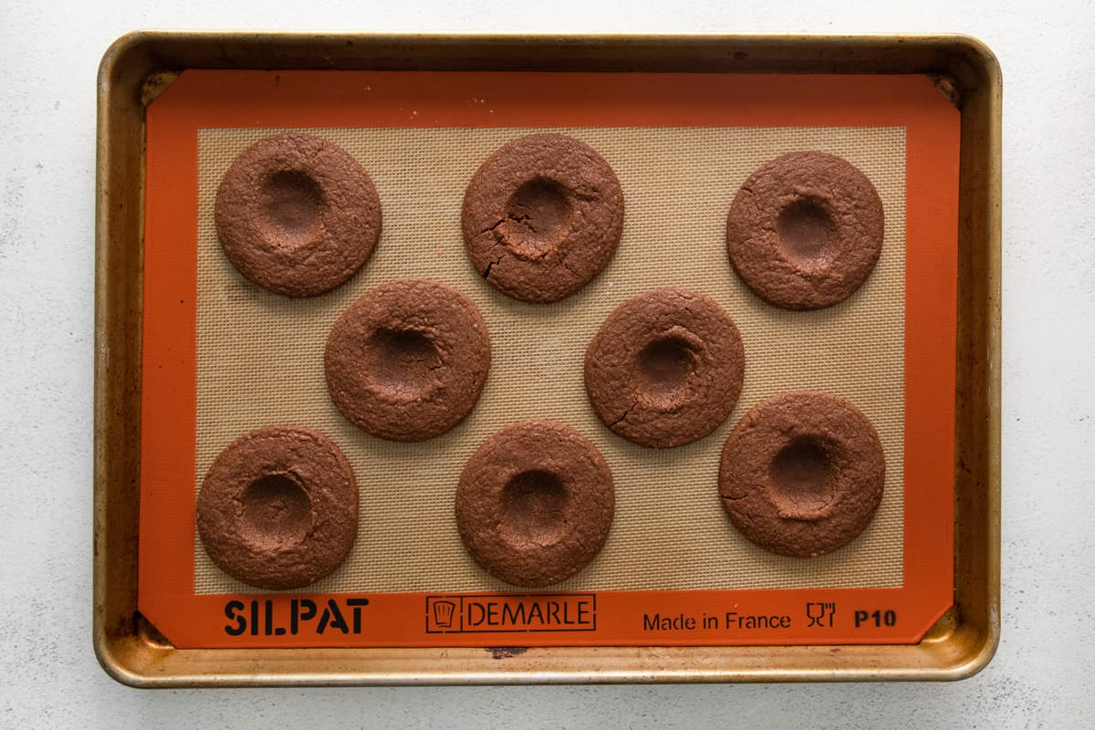 thumbprint cookies on a baking tray, before filling