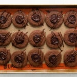 finished chocolate thumbprint cookies on a baking tray