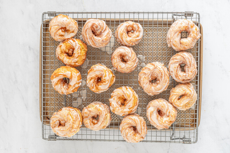 French crullers arranged on a cooling rack