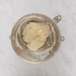 butter in a mixing bowl on a marble countertop.