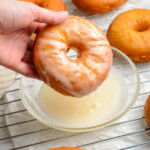 dipping donut into glaze