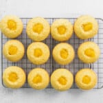 cupcakes filled with lemon curd, lined up on a cooling rack