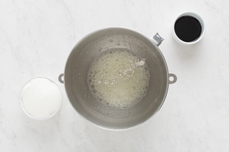 a bowl of sugar and a spoon on a marble countertop.