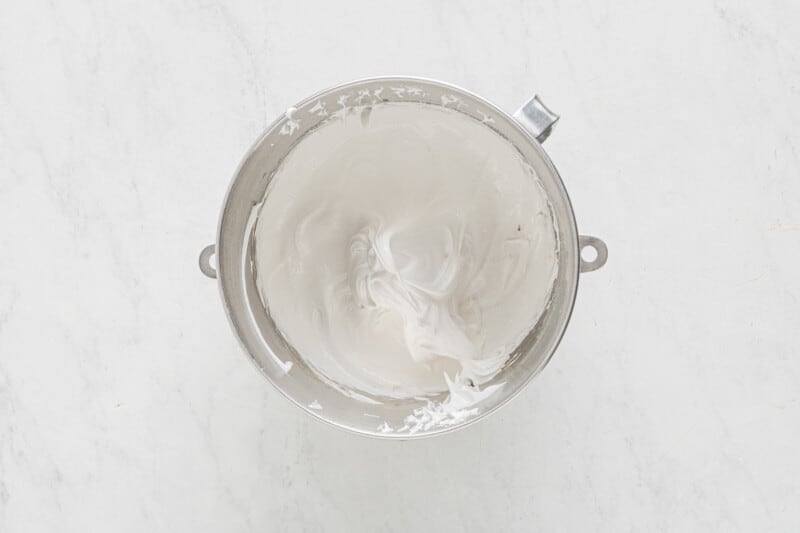 whipped cream in a bowl on a marble countertop.