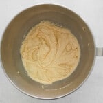 eggs and vanilla added to creamed butter, sugar, and maple syrup in a stainless mixing bowl.
