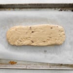 maple pecan biscotti dough patted into a 10x3 rectangle on a baking sheet.