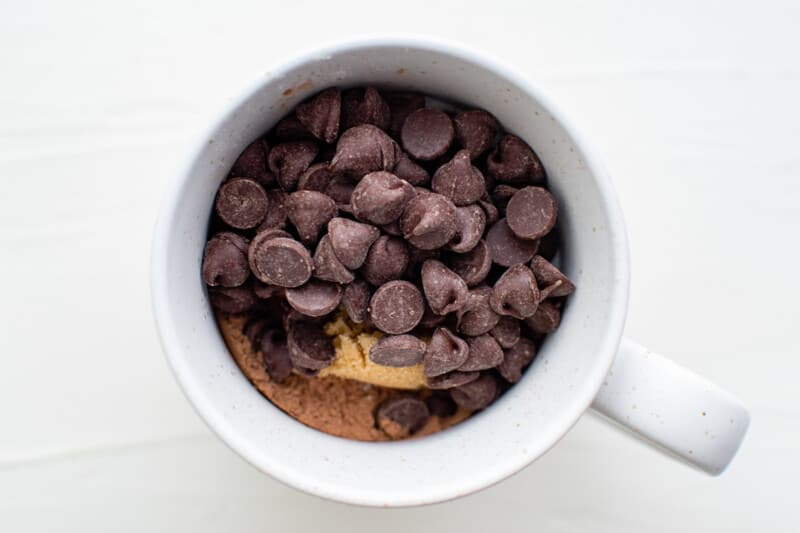 chocolate chips in a mug, on top of other ingredients