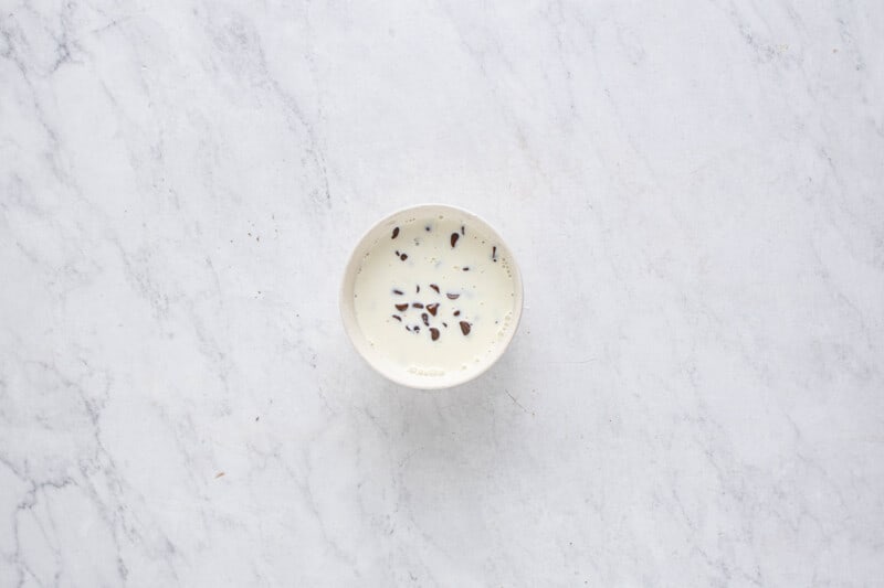 a white bowl with a spoon on a marble surface.