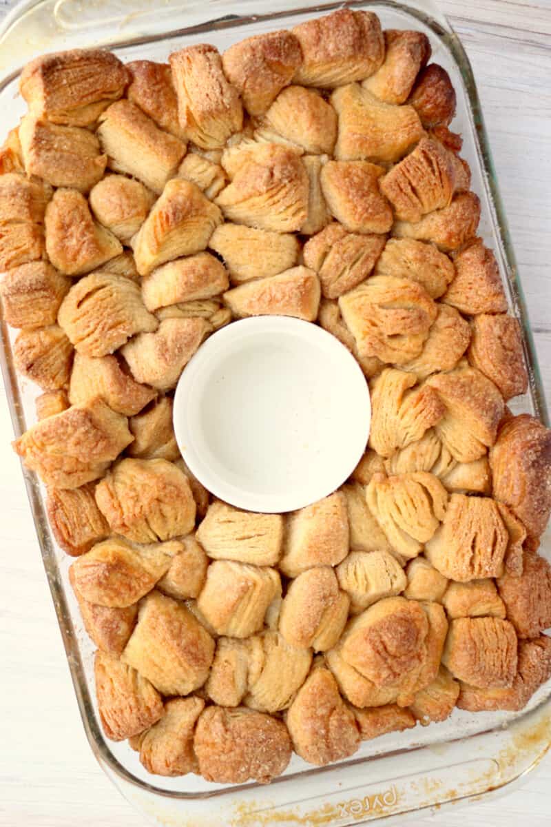 a baking dish with a bowl of cinnamon rolls in it.