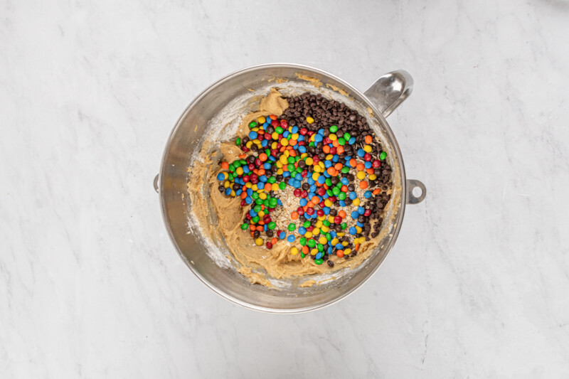 a bowl of cookie dough with sprinkles and m&m's.