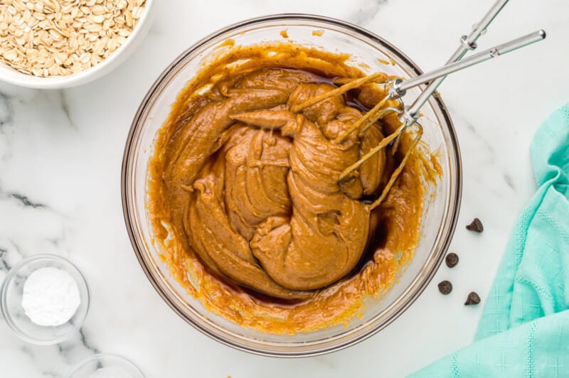peanut butter in a bowl with oats and a whisk.