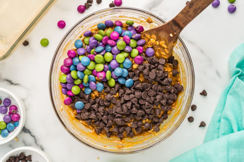 mixing chocolate chips and m&ms into batter