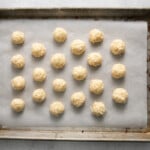 21 undipped coconut truffles on a baking sheet.