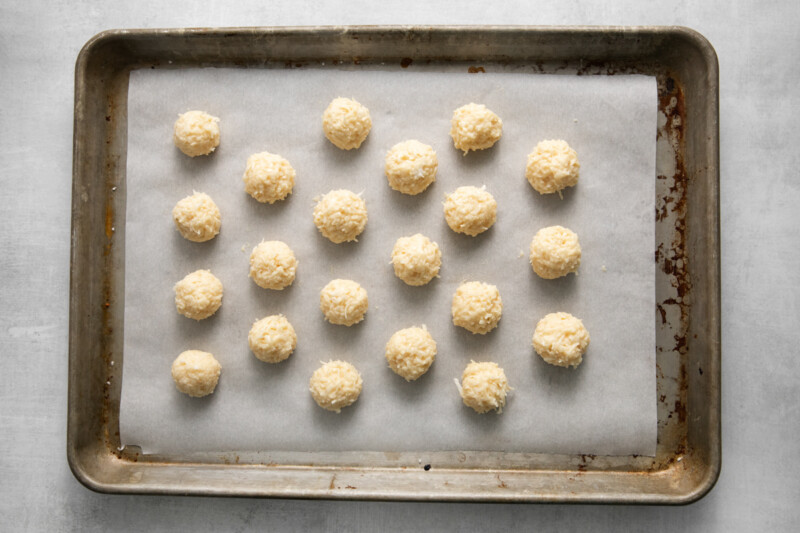 21 undipped coconut truffles on a baking sheet.