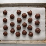 21 coconut truffles on a baking sheet.