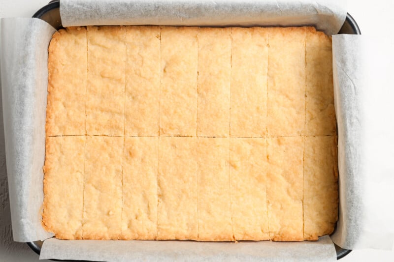 baled lemon shortbread cookies in a pan, sliced into long rectangles