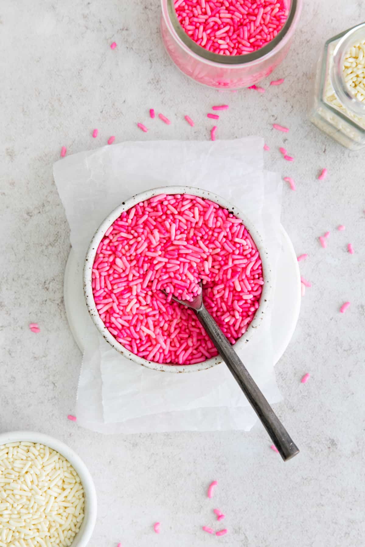 a bowl of colored sprinkles with a spoon
