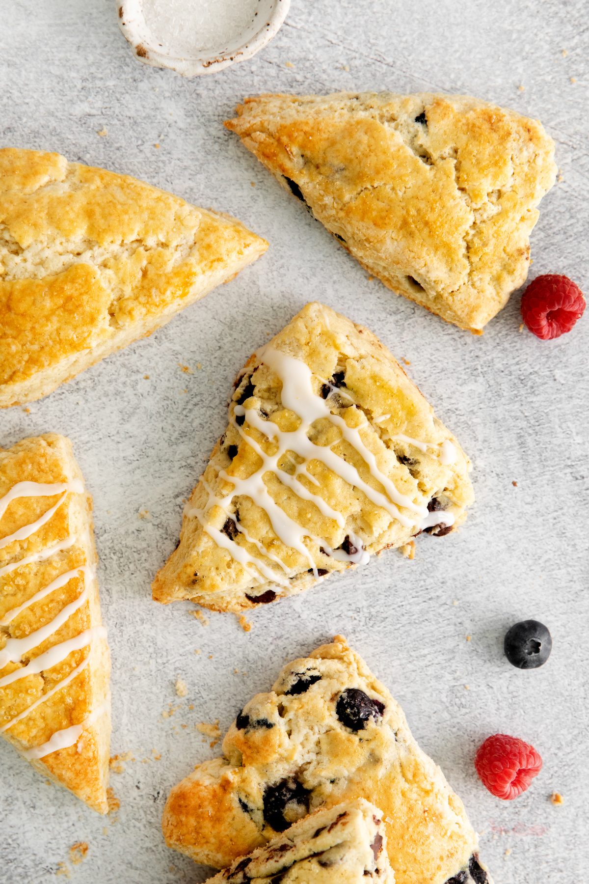 different flavors of scones, some with blueberries, some plain, some with icing drizzled on top
