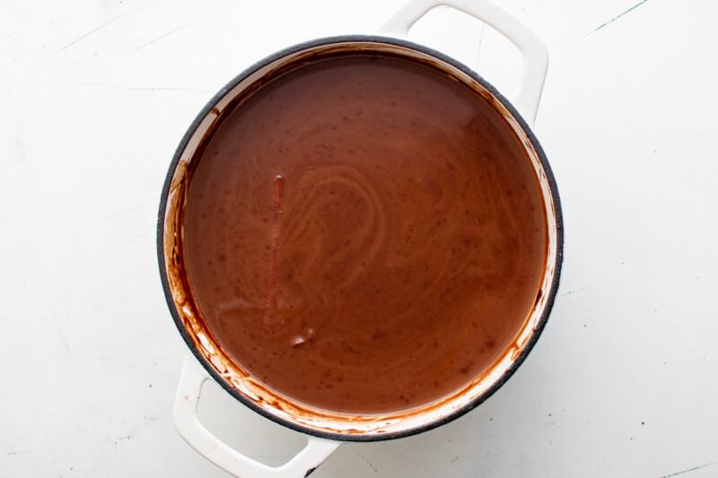 overhead view of mexican hot chocolate in a white dutch oven.