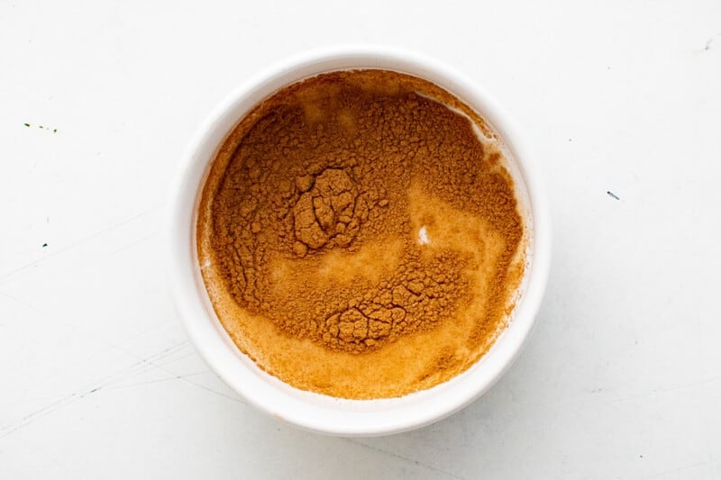 overhead view of milk and cinnamon in a small white bowl.