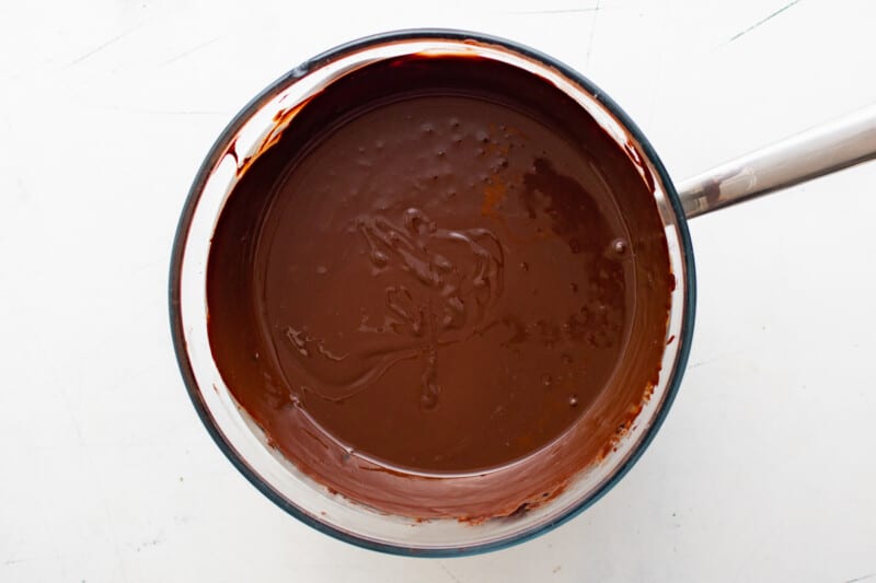overhead view of melted chocolate in a glass bowl with a spoon.