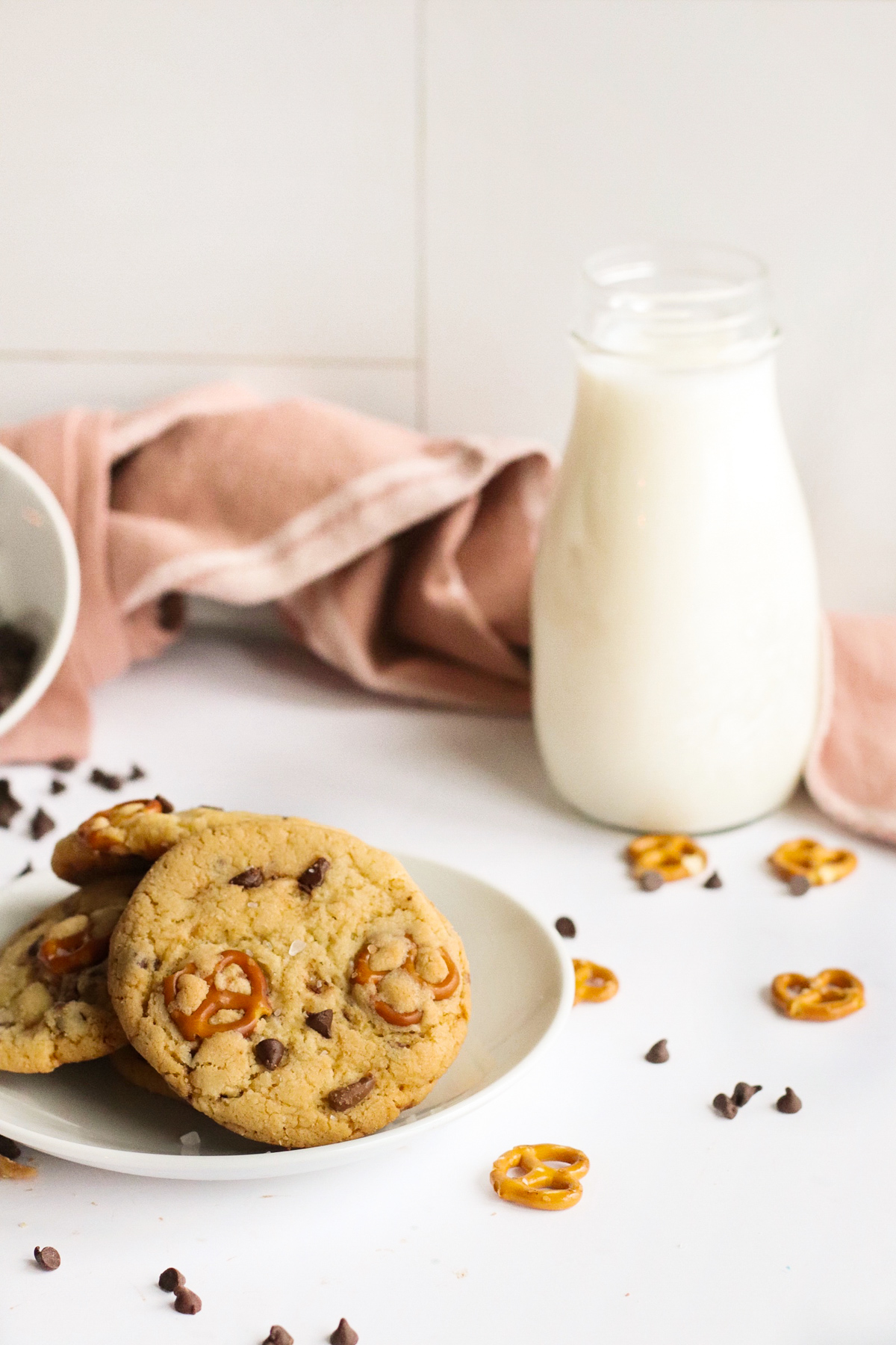 a plate of cookies with a jug of milk in the background
