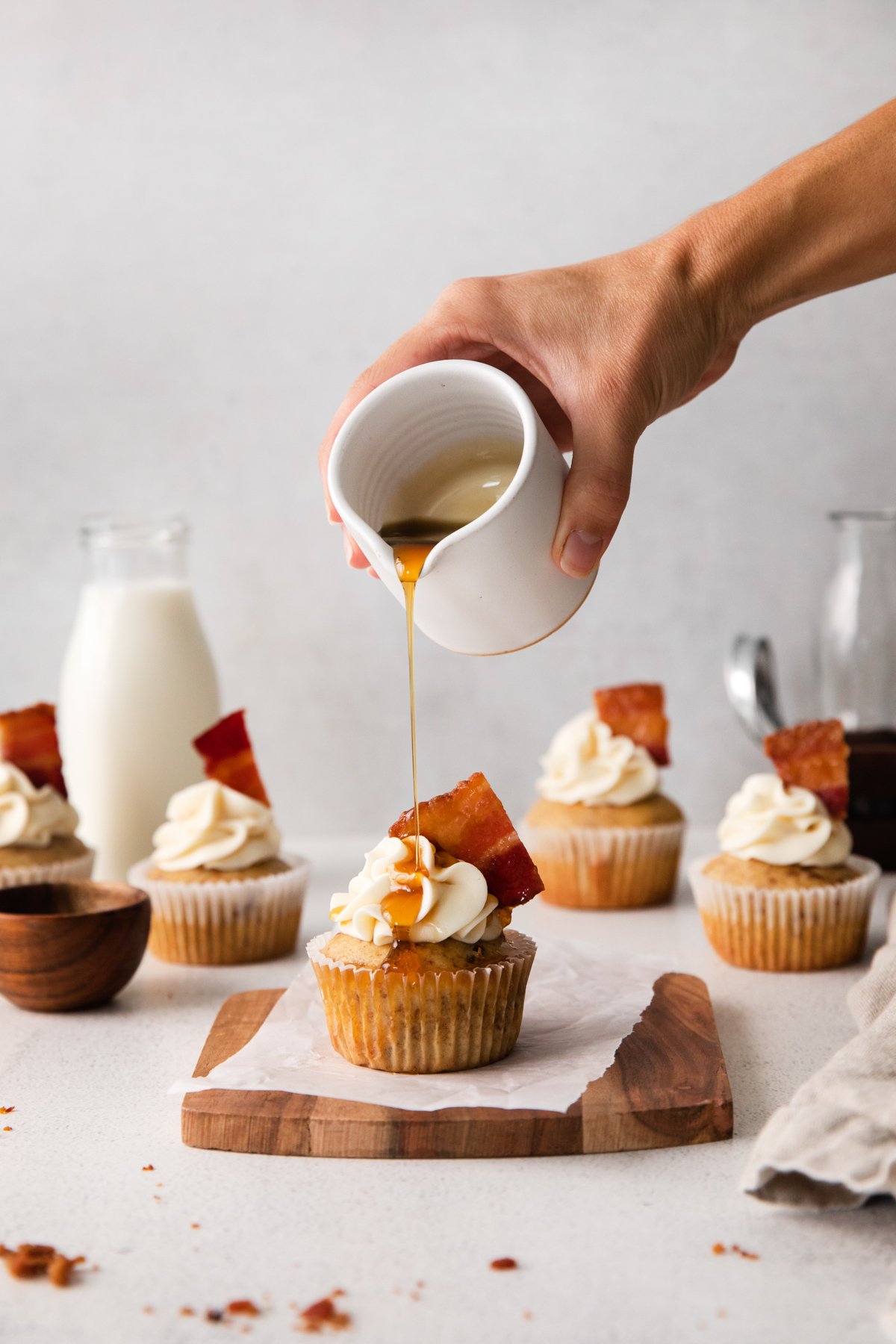pouring syrup on top of a cupcake