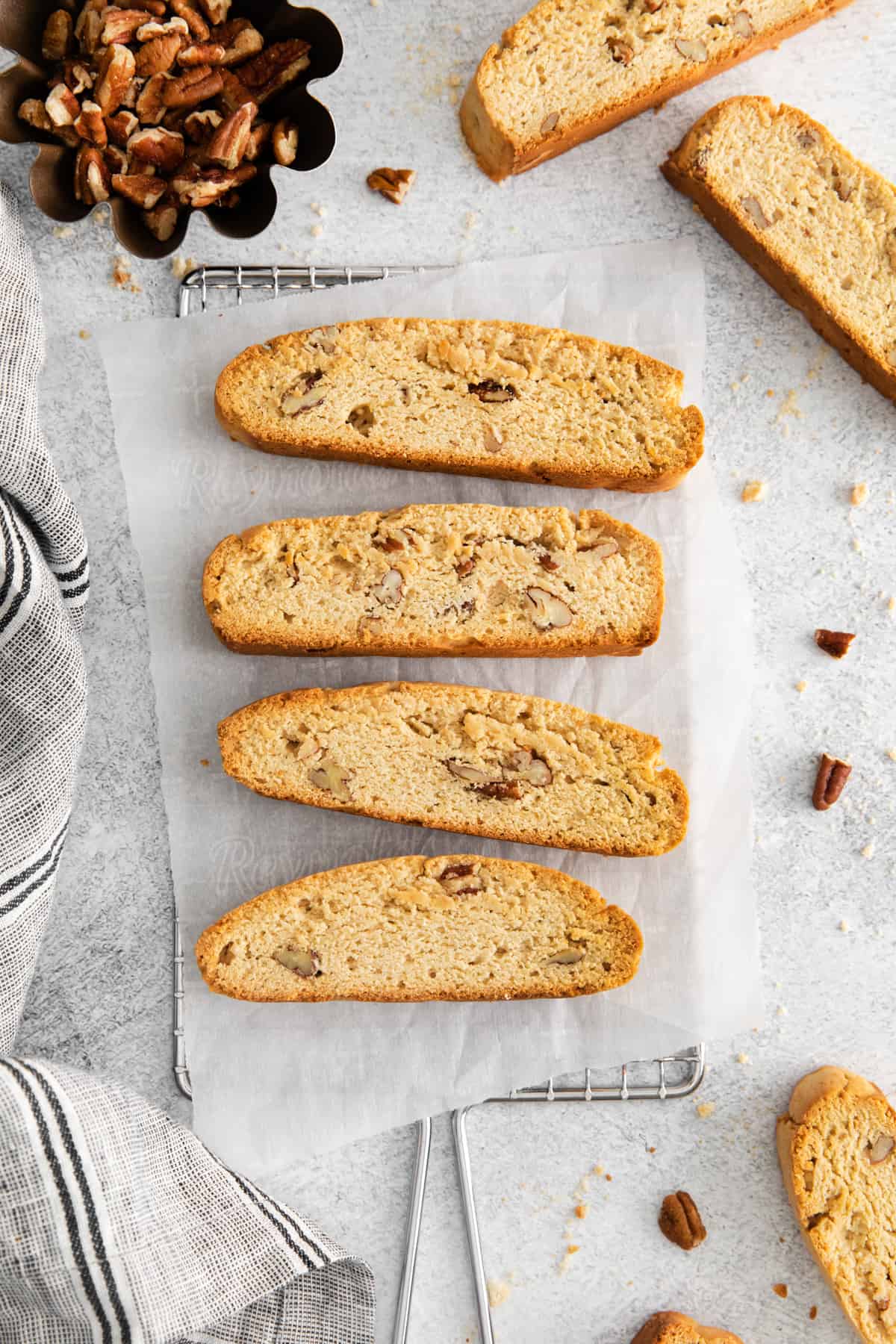 4 maple pecan biscotti on a parchment lined wire rack.